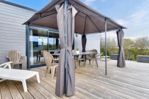 cenador con mesa y sillas en la terraza en Escapade en famille dans un domaine avec piscine, en Bretignolles-sur-Mer