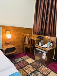 Khyber Hotel في كابول: غرفة بها مكتب وطاولة وسرير