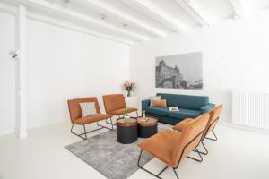 a living room with a blue couch and chairs at YAYS Amsterdam Salthouse Canal by Numa in Amsterdam