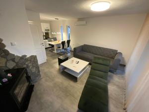 ein Wohnzimmer mit einem Sofa und einem Tisch in der Unterkunft Arena Villa Apartmani in Bihać