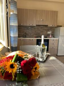 賈迪尼－納克索斯的住宿－Da Pina e Lu，厨房配有带鲜花的桌子和一瓶葡萄酒