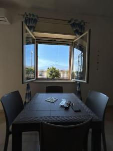 賈迪尼－納克索斯的住宿－Da Pina e Lu，餐桌、椅子和大窗户