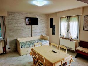 un soggiorno con tavolo e letto di Kidonia - Iseo Lake Apartmens a Sale Marasino