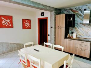 - une cuisine avec une table et des chaises blanches dans la chambre dans l'établissement Kidonia - Iseo Lake Apartmens, à Sale Marasino
