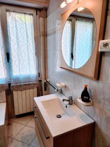 y baño con lavabo y espejo. en Kidonia - Iseo Lake Apartmens en Sale Marasino
