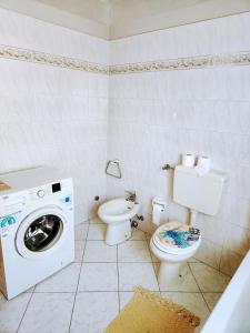bagno con lavatrice e servizi igienici di Kidonia - Iseo Lake Apartmens a Sale Marasino