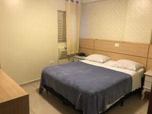 a bedroom with a large bed with two pillows at Hotel Makuxis - Brigadeiro in São Paulo