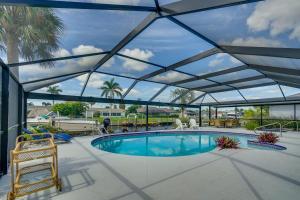 a swimming pool with a retractable roof at Beachy Cape Coral Home - Swim, Fish, Boat! in Cape Coral