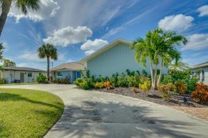 a house with palm trees and a driveway at Beachy Cape Coral Home - Swim, Fish, Boat! in Cape Coral