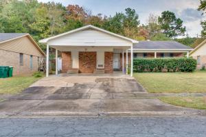 a brick house with a driveway in front of it at Lovely Little Rock Home with Fire Pit and Yard! in Little Rock