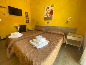 Habitación de hotel con 2 camas y toallas. en Hotel Eva La Romantica en Moneglia