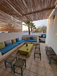 ein Wohnzimmer mit einem blauen Sofa und Stühlen in der Unterkunft Dar Douja à Chaffar / Ton chez-toi près de la plage in Nakta