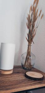 a vase with dry grass in it on a table at Apartamento en el centro de Elche con terraza in Elche