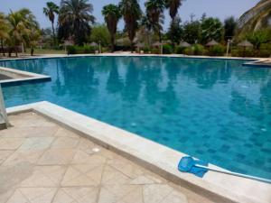 a swimming pool with blue water in a resort at Appartement à Saly in Saly Portudal
