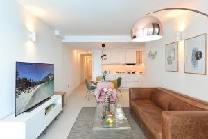 a living room with a couch and a television at El Balcon Azul de Taliarte by VillaGranCanaria in Telde