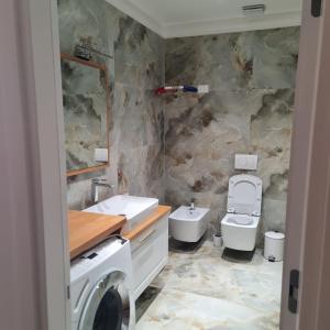 a bathroom with a sink and a washing machine at Blue Horizon 1 in Vlorë