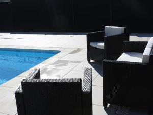 a group of chairs sitting next to a swimming pool at Domaine du parc in Grandvillers