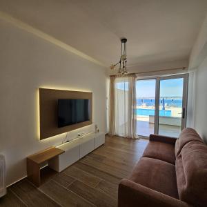 a living room with a couch and a flat screen tv at Blue Horizon 1 in Vlorë