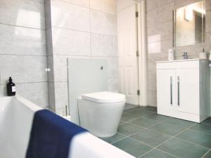 a bathroom with a toilet and a sink and a tub at Luxury 2 Bed, 2 Bath Apartment in Central Watford in Watford