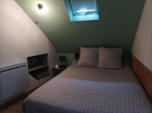 a small bedroom with a bed with a window at Le cocon d'Emma, à 40mn d'Europapark in Ottmarsheim