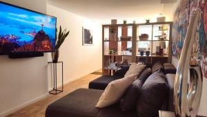 a living room with a couch and a flat screen tv at Xanten Basement Suite in Xanten