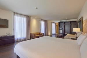 um quarto de hotel com uma cama grande e uma sala de estar em Puro Hotel Oasis Urbano em Palma de Maiorca