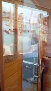 una doccia con porta in vetro con barche in acqua di il Grottino di Giannas a Pozzuoli