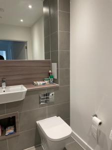 a bathroom with a white toilet and a sink at Brand New Stunning 2-Bed Apartment in Dagenham in Dagenham