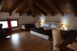 1 dormitorio con 2 camas en una habitación con suelo de madera en Bienestar - Maison de Charme, en Alghero