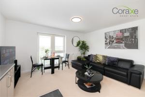 un soggiorno con divano nero e tavolo di Modern 2 Bedroom Urban Oasis a Kent