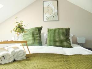 Luxury 2 Bed, 2 Bath Apartment in Central Watford في واتفورد: غرفة نوم بسرير ومخدات خضراء وطاولة