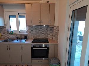 a kitchen with a sink and a stove top oven at Sunrise guest house in Nydri