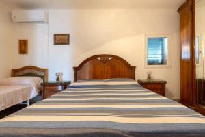 - une chambre avec un grand lit et 2 tables de chevet dans l'établissement Villa Serenità Vintage Charm a Lido Marini, à Lido Marini