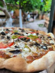 a pizza with olives and peppers on a table at Litost Cafe Bungalow in Adrasan