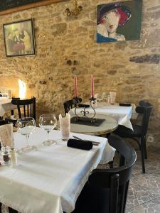 a restaurant with two tables with white tablecloths and candles at Hôtellerie de l'Abbaye Saint Amand in Saint-Amand-de-Coly