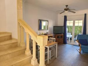 ein Wohnzimmer mit einer Treppe und einem TV in der Unterkunft Bungalow PUEBLO MAR en Els Poblets. in Denia