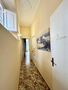 um corredor com piso em azulejo e uma porta em Casa MiRè em Catânia