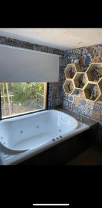 uma banheira na casa de banho com uma janela em Santuyoc Lodge em Volcán
