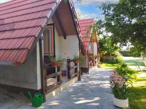 een huis met een rood dak en potplanten bij One bedroom bungalow with enclosed garden and wifi at Brinjani in Brinjani
