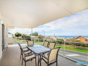a table and chairs on a balcony with a view of the ocean at The Block Escape - Ocean Views No 6 in Victor Harbor