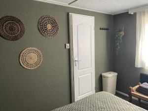 een slaapkamer met groene muren en een witte deur bij Chalet Maiva - De Krabbenkreek in Sint Annaland