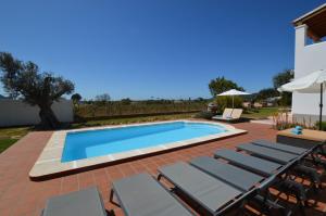 uma piscina com espreguiçadeiras e uma villa em Cas Torres em Sant Jordi