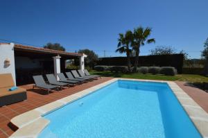 einen Pool mit Stühlen und ein Haus in der Unterkunft Cas Torres in Sant Jordi