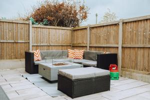eine Terrasse mit einem Sofa, einem Tisch und einem Zaun in der Unterkunft Luxury Recently Renovated 3 Bedroom home in Sandwich Kent in Sandwich
