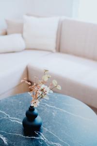 a small blue vase with flowers on a table at Euphoria Apartment in Alexandroupoli