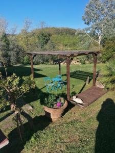 a wooden pergola with a table and a chair in a yard at Agriturismo Campolungo in Sant'Ermo