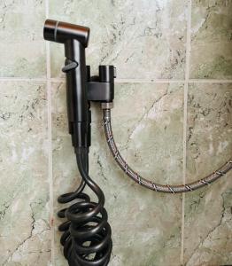 een zwart spuitpistool dat aan de muur hangt bij Villa Garden Shkodra in Shkodër