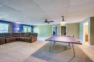 ein Wohnzimmer mit einem Sofa und einem Tisch in der Unterkunft Milledgeville Home with Game Room and Private Dock! in Resseaus Crossroads