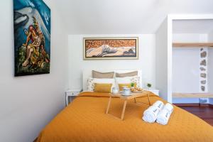 1 dormitorio con 1 cama con colcha de color naranja en Gerês Escape Retreat - Casa da Fonte de Pedra, en Vieira do Minho
