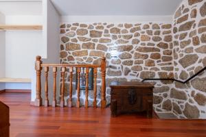 um quarto com uma parede de pedra e uma escada em Gerês Escape Retreat - Casa da Fonte de Pedra em Vieira do Minho
